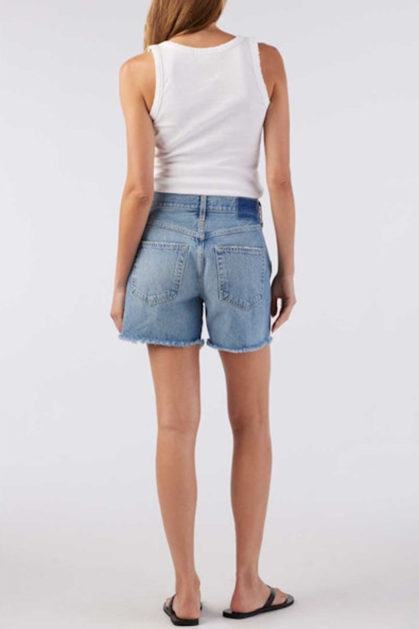 Image of model wearing AMO Denim Billie Shorts in Free Spirit Lightwash. Billie is a 100% cotton baggy short with a mid rise and raw hem. Designed and made in Los Angeles.