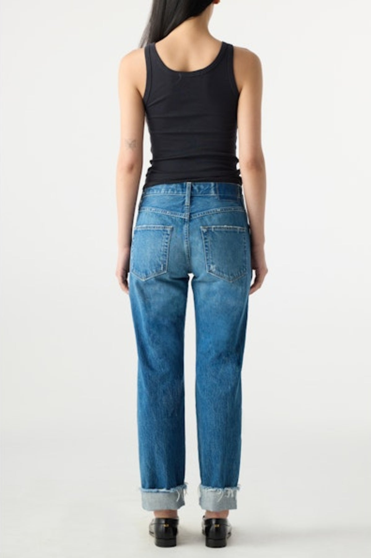 Image of model wearing AMO DENIM Camryn Jean in Magnetic. Cameron is a mid-rise 100% Cotton mid-wash denim with a tapered, straight leg opening. Designed to wear with cuffed hem.
