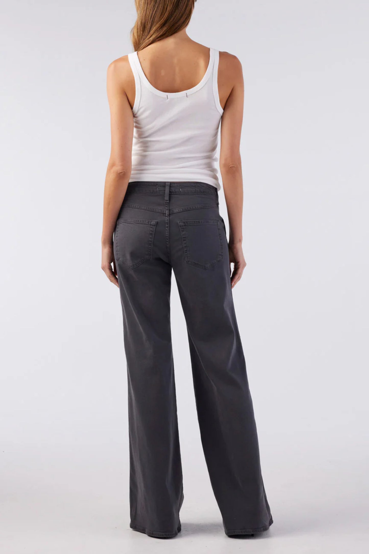 Image of model wearing AMO Denim Elizabeth Flare Jean in Pewter Black. Elizabeth Flare is a Premium Mid-Rise Denim with a Bell Bottom Flare Leg Opening. Made in Los Angeles from Eco-Friendly Cotton-Lyocell Denim.