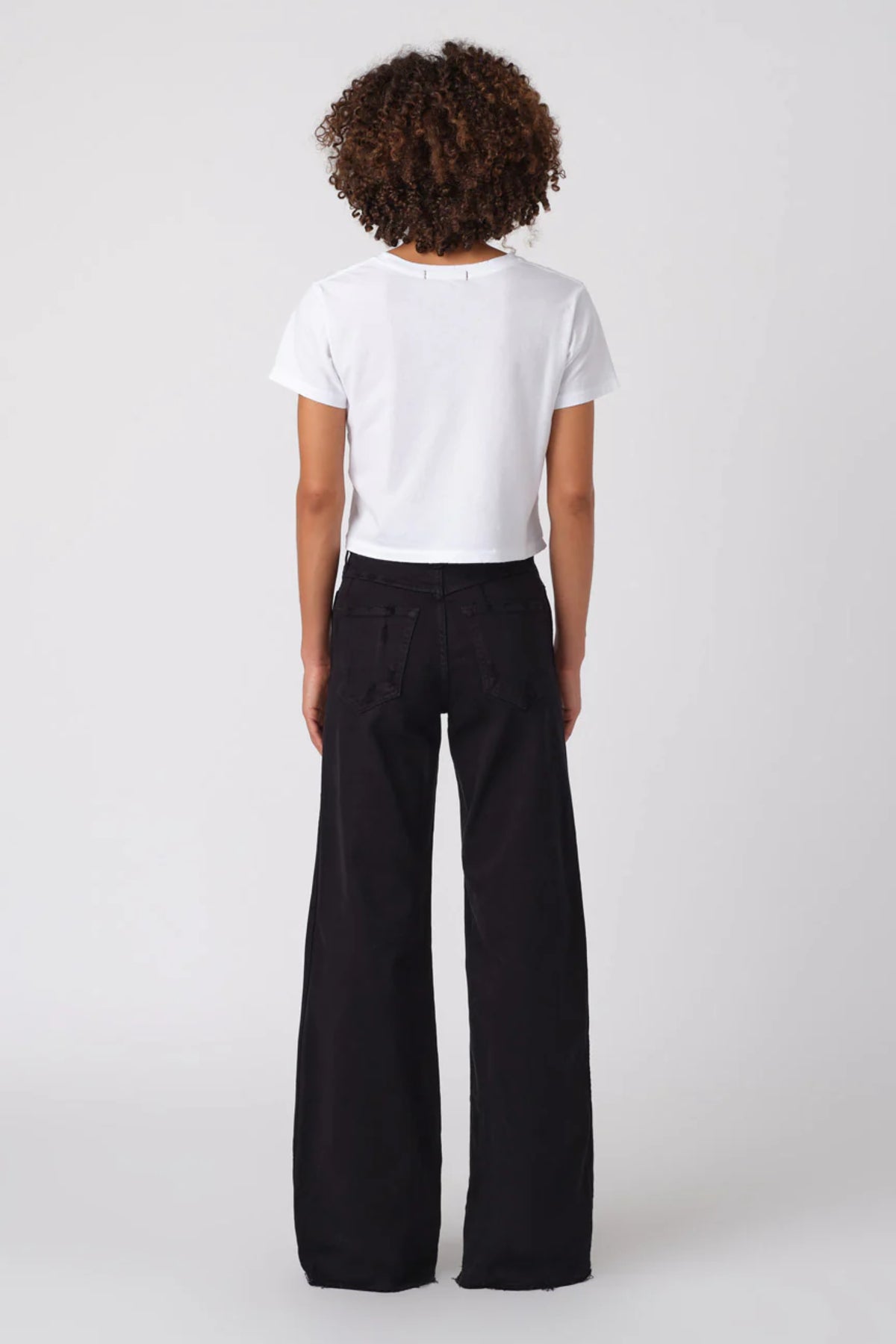 Image of model wearing AMO DENIM Friday Wide Leg in Black Oak. Frida is a high rise, wide leg sailor cut jean in a true black wash.