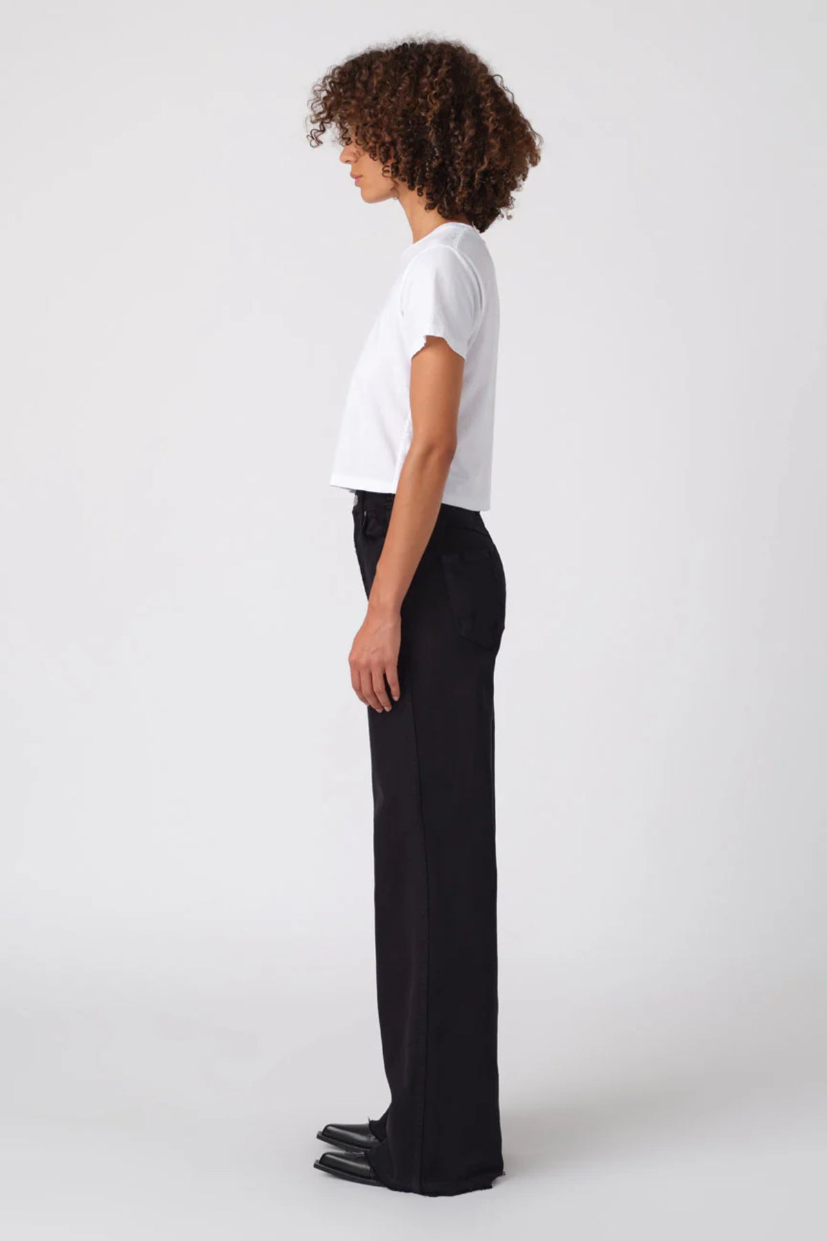 Image of model wearing AMO DENIM Friday Wide Leg in Black Oak. Frida is a high rise, wide leg sailor cut jean in a true black wash.