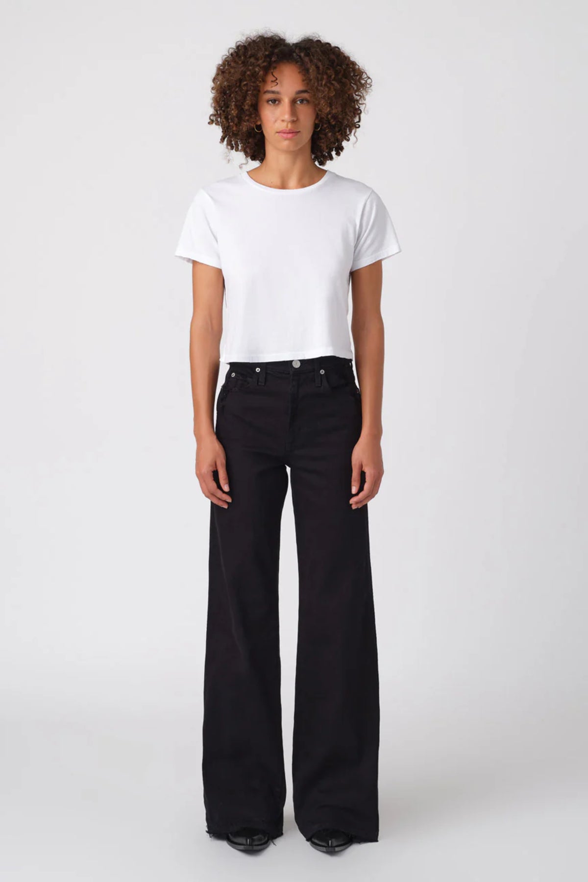 Image of model wearing AMO DENIM Friday Wide Leg in Black Oak. Frida is a high rise, wide leg sailor cut jean in a true black wash.