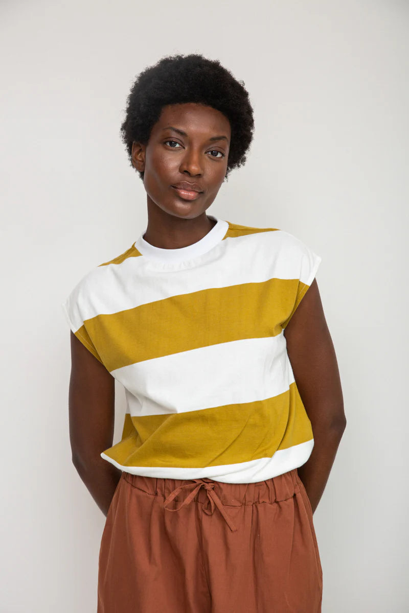 Image of model wearing Beaumont Organic Aukui T-Shirt in True White. Aukui is a cap sleeve tee with high crew neck and medium body length. Ethically made in Portugal from organic cotton.