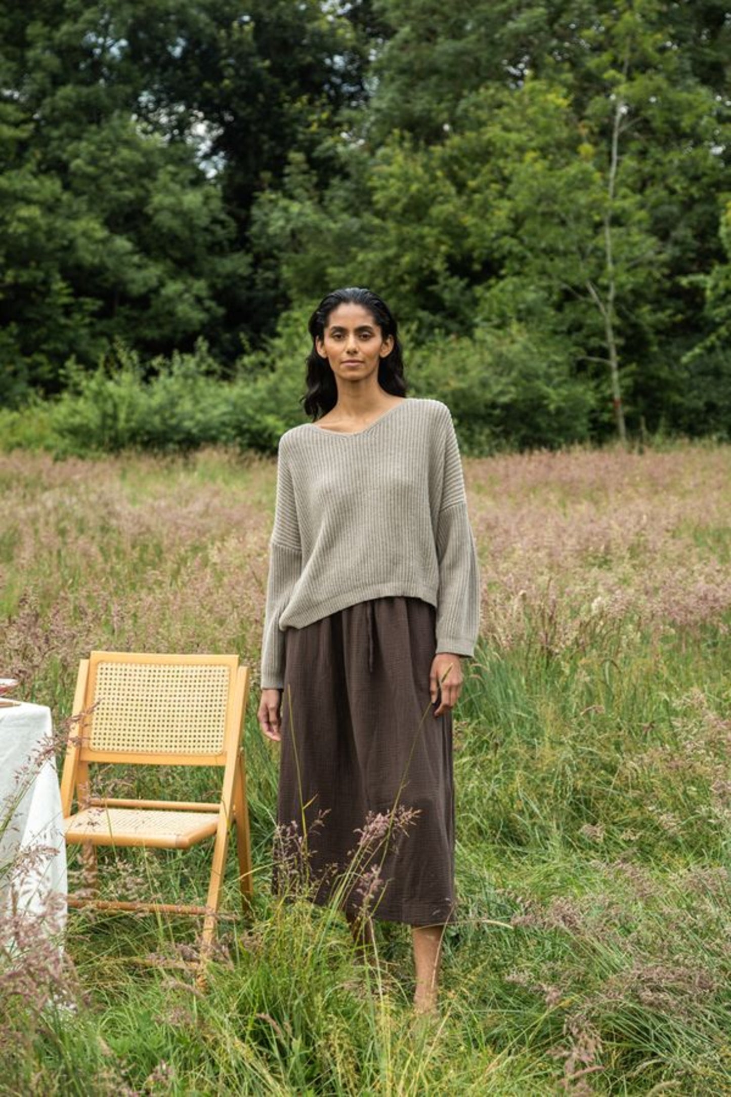 Image of model wearing Beaumont Organic Brooke Leigh Reversible Open Back Sweater in Natural Beige. Brook Leigh is a medium length, long sleeve sweater with a twist knot detail on one side and boat neck finish on the other side. Ethically made in Portugal from recycled Cotton yarns.