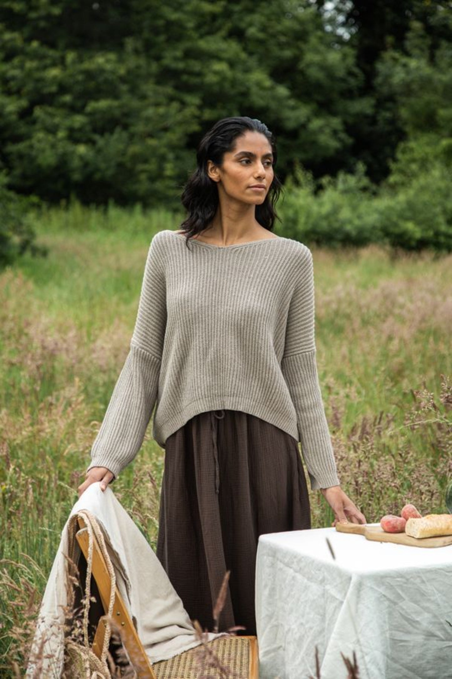 Image of model wearing Beaumont Organic Brooke Leigh Reversible Open Back Sweater in Natural Beige. Brook Leigh is a medium length, long sleeve sweater with a twist knot detail on one side and boat neck finish on the other side. Ethically made in Portugal from recycled Cotton yarns.