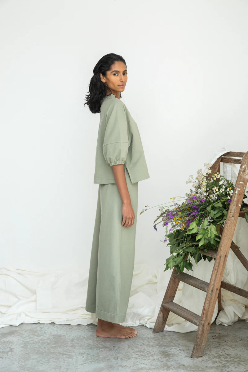 Image of model wearing Beaumont Organic Helios Sweatshirt in Pistachio Green Felpe Cotton. Helios is a medium length sweatshirt top with fashionable princess sleeves that hit at the elbow. Ethically made in Portugal from organic Cotton.