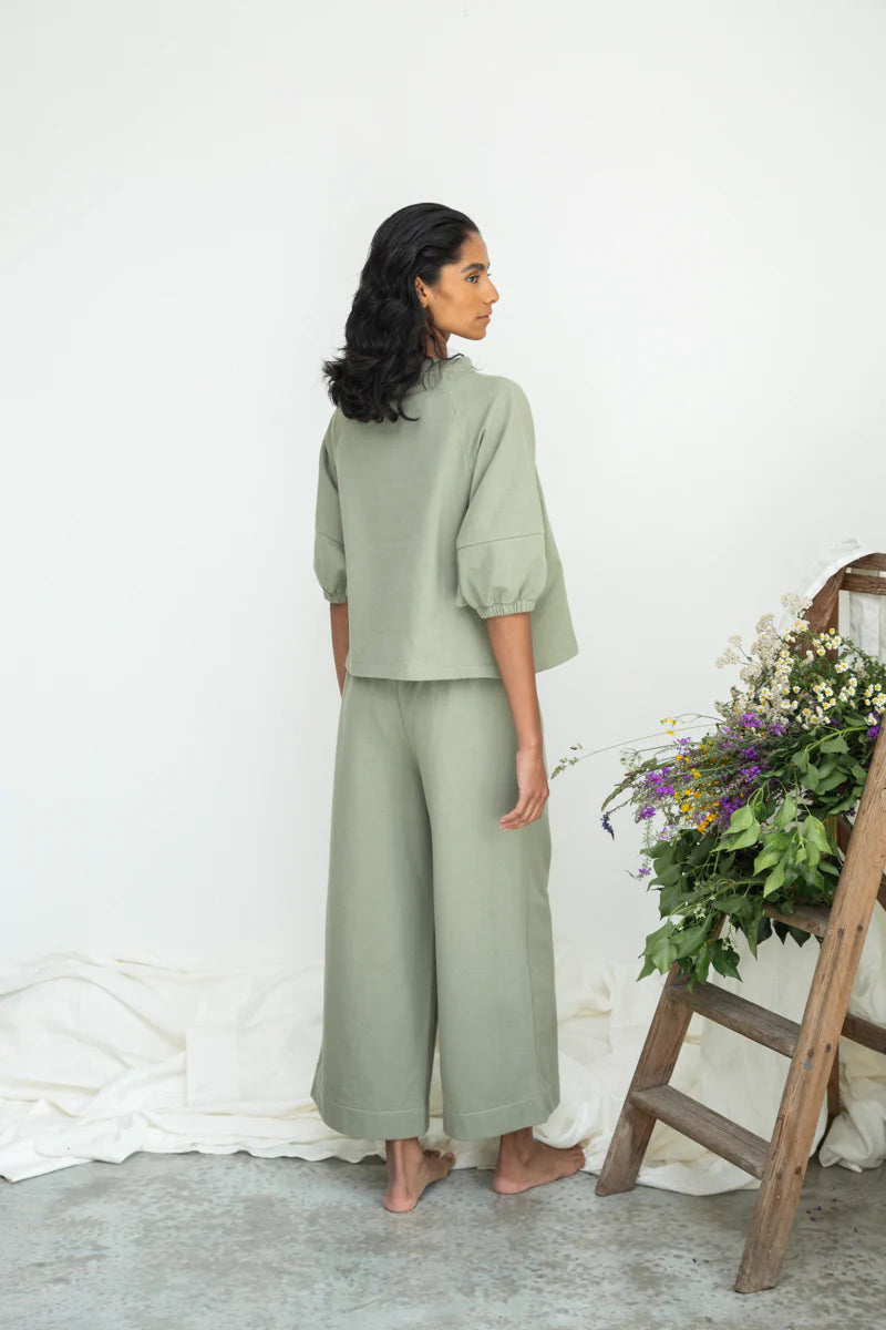 Image of model wearing Beaumont Organic Helios Sweatshirt in Pistachio Green Felpe Cotton. Helios is a medium length sweatshirt top with fashionable princess sleeves that hit at the elbow. Ethically made in Portugal from organic Cotton.