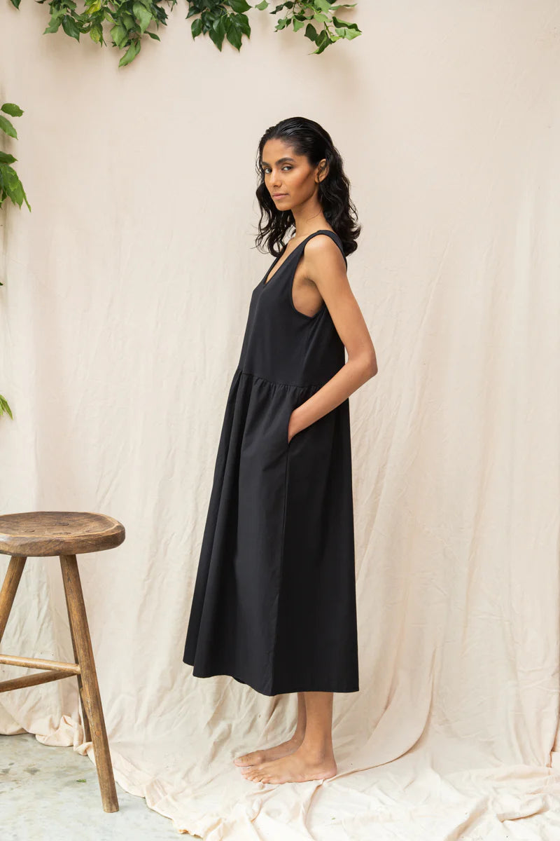 Image of model wearing Beaumont Organic Rory Coton Jumpsuit in black. Rory is a pull on style sleeveless jumpsuit with a scoop neck, relaxed waistline, and wide culotte style leg opening. Cropped fit. Ethically made in Portugal from organic cotton.