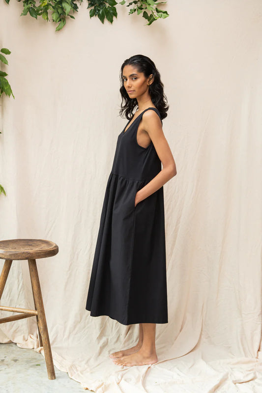 Image of model wearing Beaumont Organic Rory Coton Jumpsuit in black. Rory is a pull on style sleeveless jumpsuit with a scoop neck, relaxed waistline, and wide culotte style leg opening. Cropped fit. Ethically made in Portugal from organic cotton.