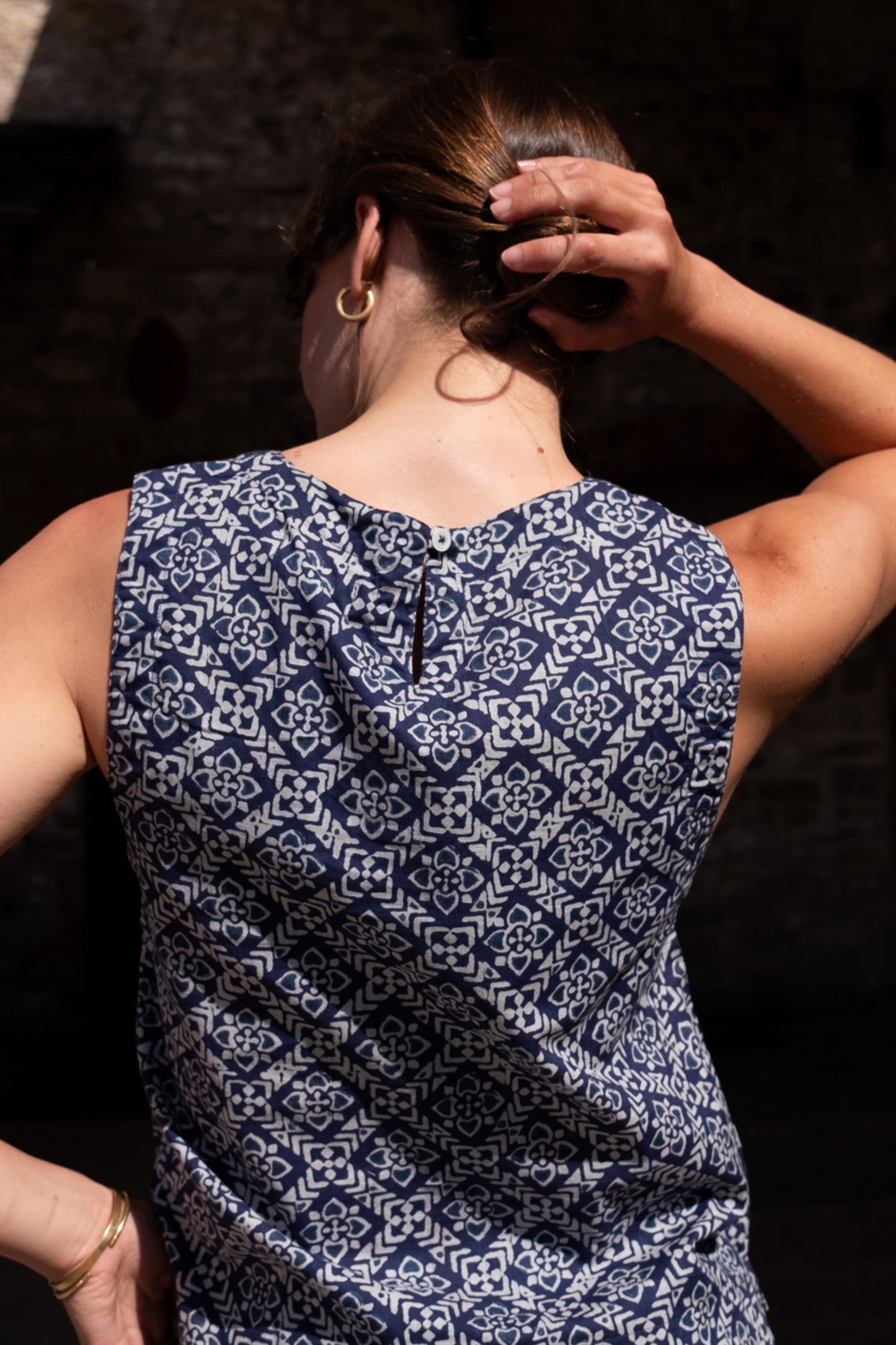 Image of model wearing BIBICO Pippa Sleeveless Top in Indigo Block Print. Pippa Top is a crew neck, medium length, sleeveless shell top. Made by Fair Trade Certified Producers using Hand Block Printed Organic Cotton Fabric.