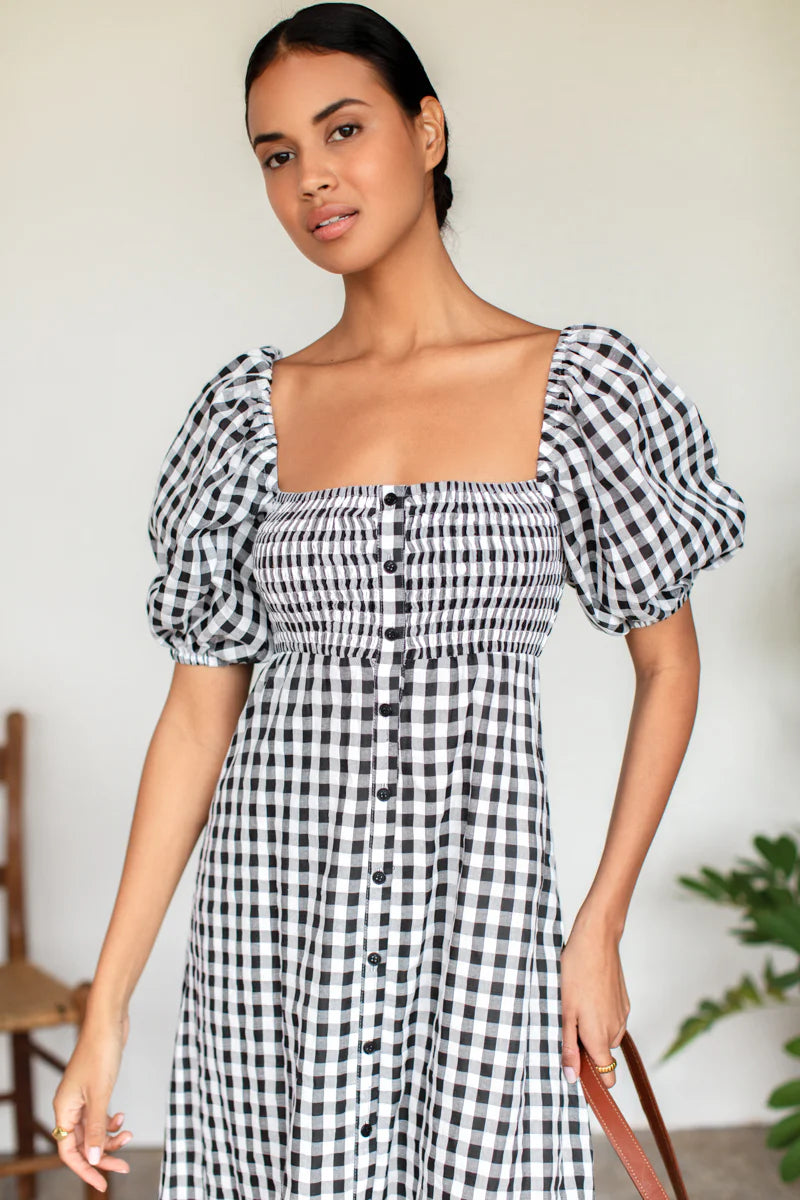 Image of model wearing Emerson Fry Love Tomas Santiago Maxi Dress in Black + White Gingham Check. Santiago dress has a square neckline, shirred bodice, short puff sleeve, and full length skirt with button front closure.