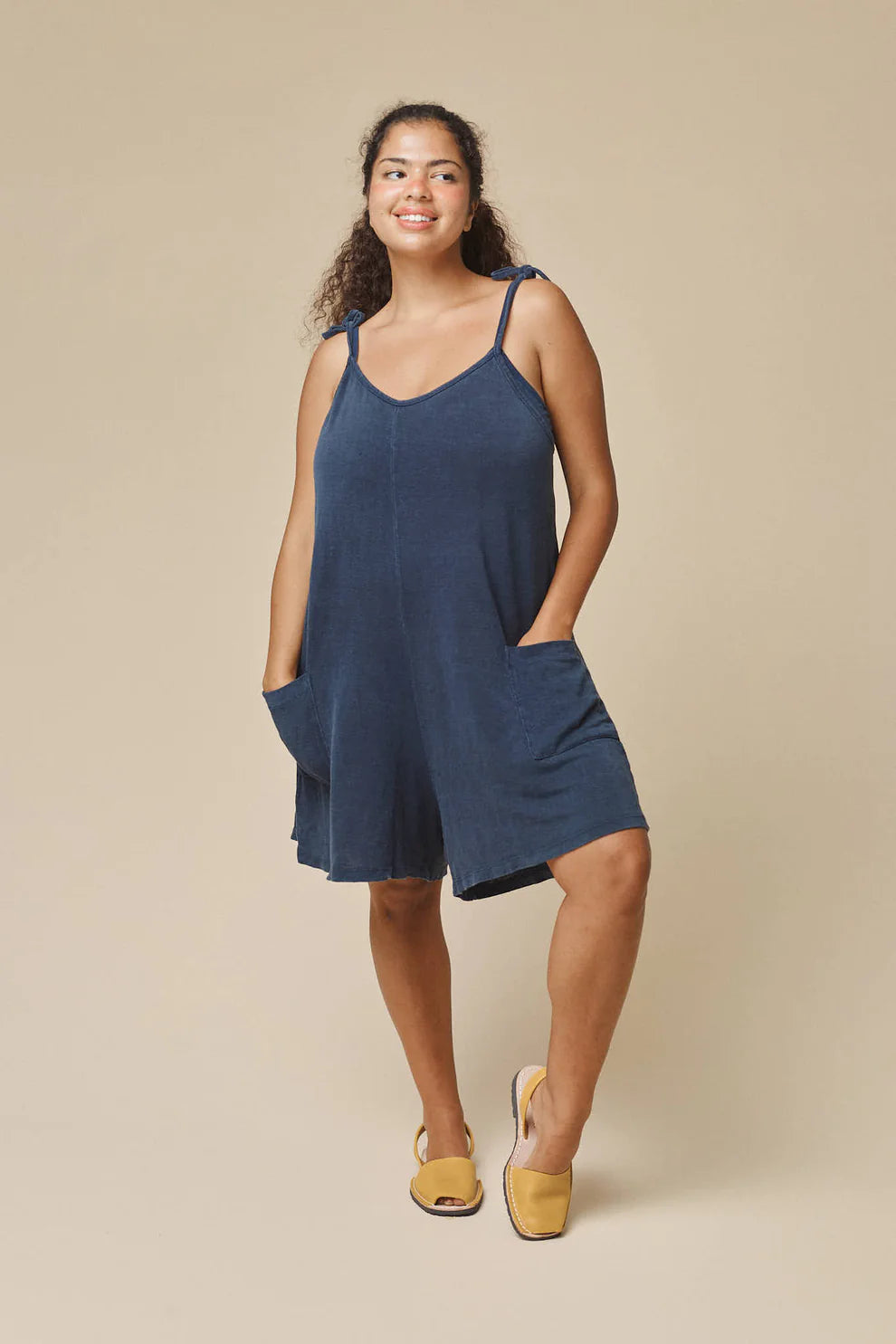 Image of Jungmaven Sespe Romper in Navy Blue. Sespe Romper is a short coverall style romper with front patch pockets and adjustable spaghetti straps that tie at shoulder. Made in USA from Hemp-Organic Cotton Blend fabric.
