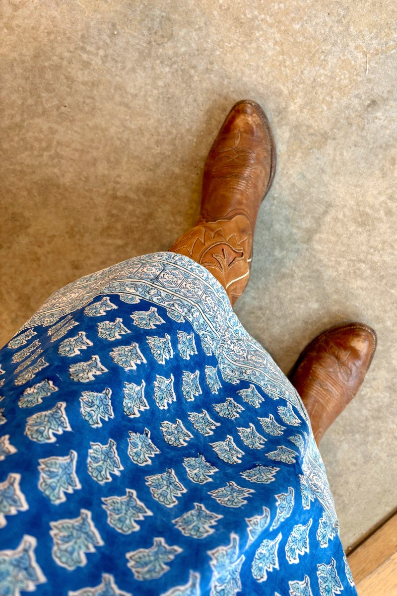 Image of model wearing MAELU DESIGNS Pull-On Drawstring Midi Skirt in Willow Ikat Print. Willow Print is a blue Ikat inspired floral print hand block printed on lightweight cotton.