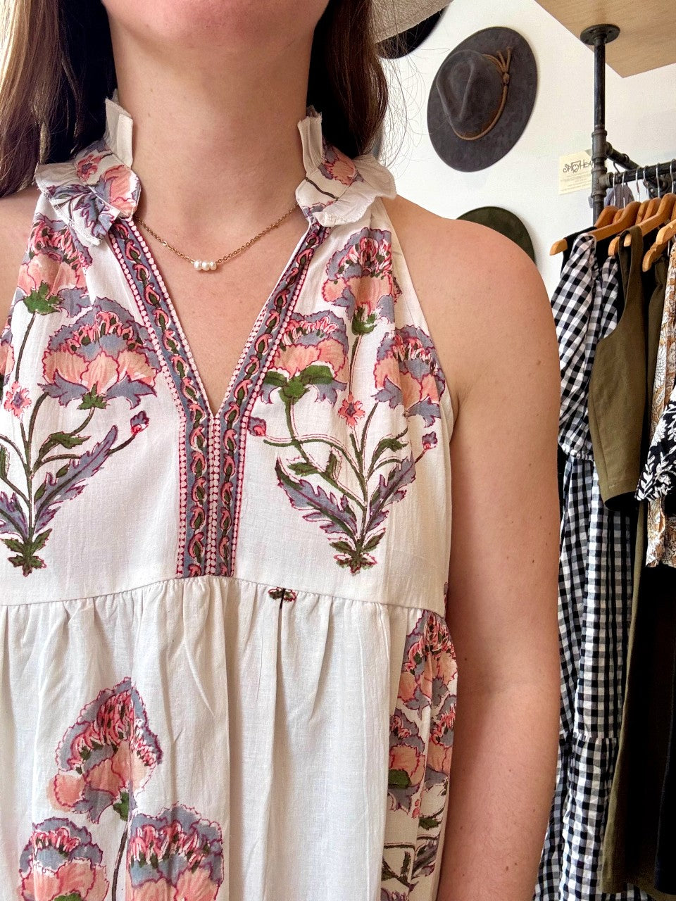 Image of model wearing MAELU DESIGNS Poppy Tiered Sundress. Poppy dress is a halter style sundress with flowing, tiered a line skirt, v-neck opening, and frilled bodice in a hand block printed Mischa Floral Cotton.