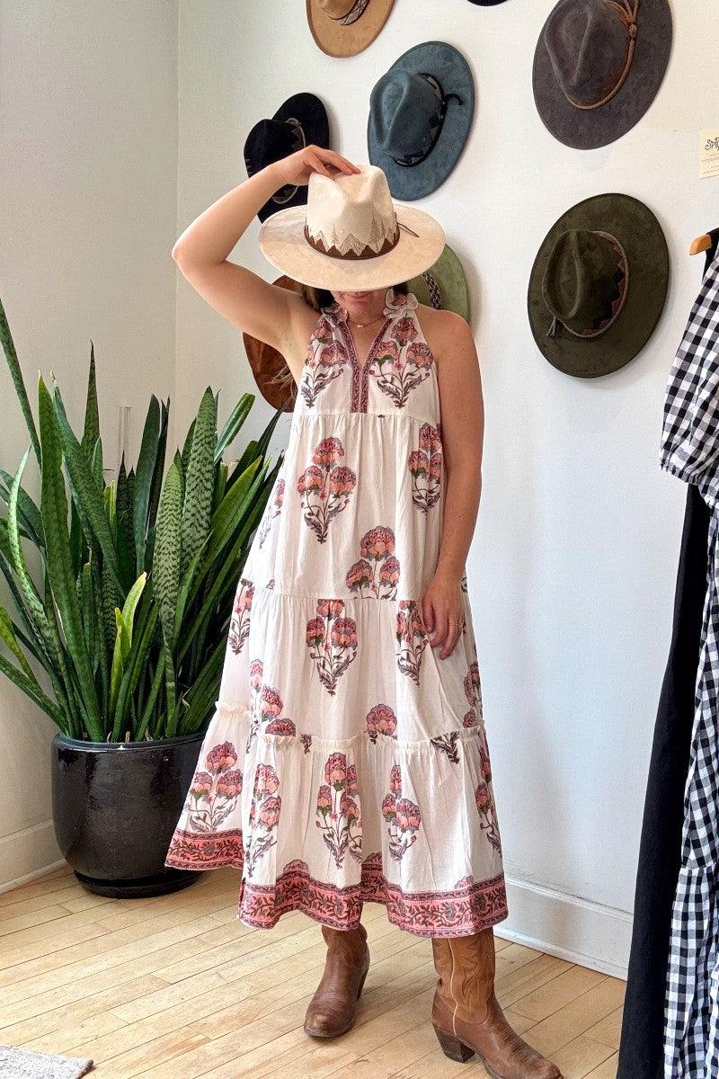 Image of model wearing MAELU DESIGNS Poppy Tiered Sundress. Poppy dress is a halter style sundress with flowing, tiered a line skirt, v-neck opening, and frilled bodice in a hand block printed Mischa Floral Cotton.