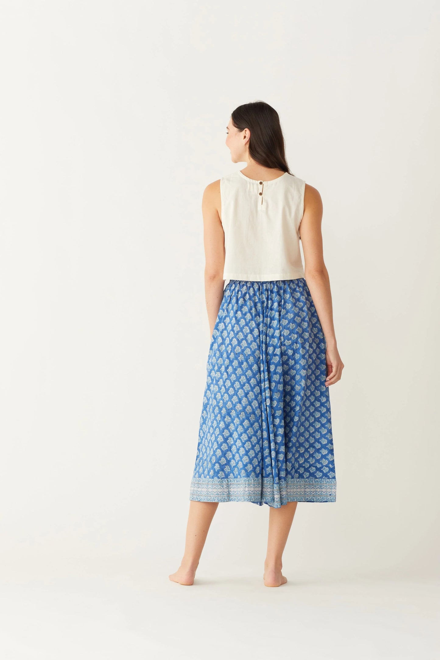 Image of model wearing MAELU DESIGNS Pull-On Drawstring Midi Skirt in Willow Ikat Print. Willow Print is a blue Ikat inspired floral print hand block printed on lightweight cotton.