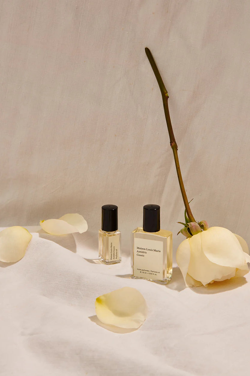 MAISON LOUIS MARIE Roll On Perfume Bottles in Shown in Studio with White Roses _ Antidris Cassis 0.5 fl oz personal fragrance