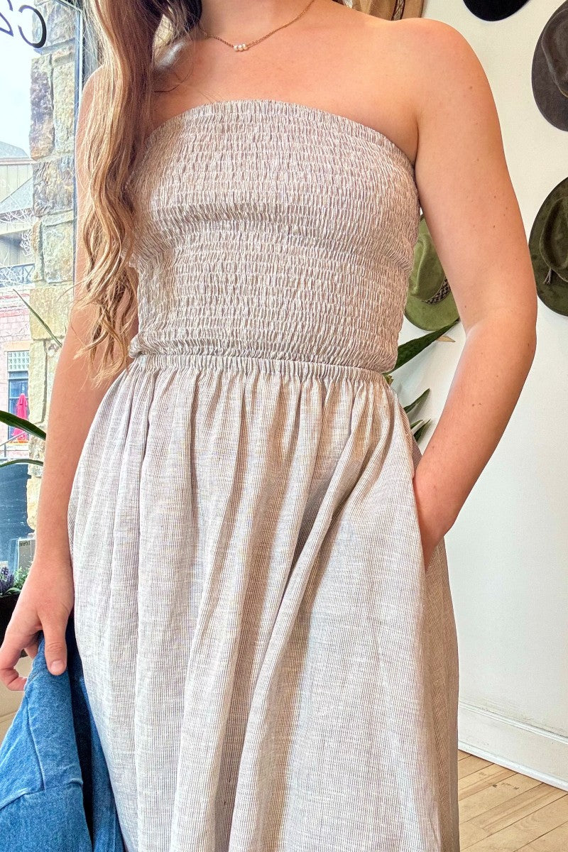Image of NARY RESORT Shirred Tube Midi Sundress in Grey Stripe Deadstock linen. This midi length dress has a gathered, pintuck bodice, a-line skirt, and side pockets. Ethically made in Cambodia.