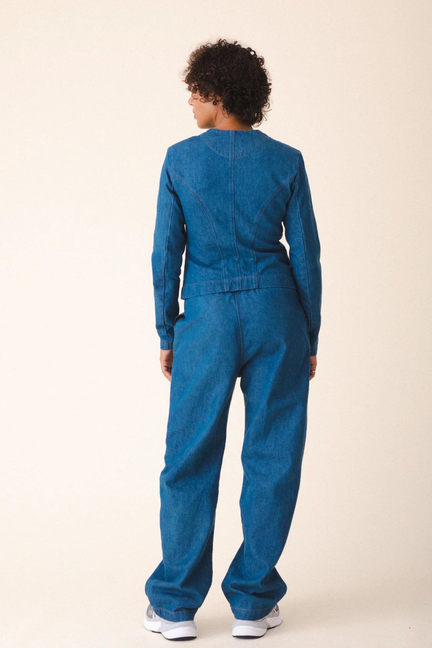 Image of model wearing Prairie Underground Dune Tailored Jean Jacket. Dune Jacket is a tailored collarless jacket with a hidden zip front closure. Designed and produced in Seattle, Washington.