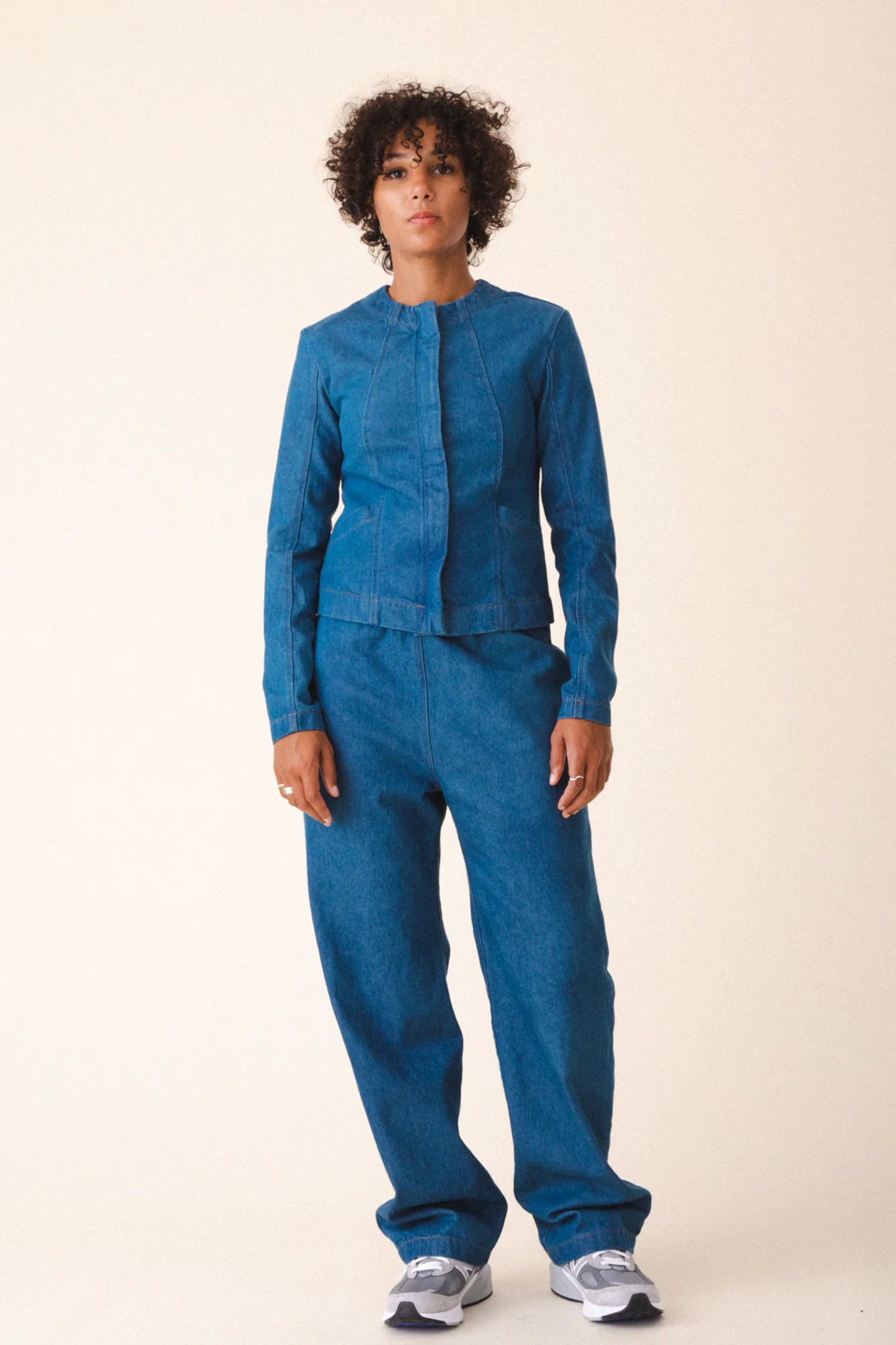 Image of model wearing Prairie Underground Dune Tailored Jean Jacket. Dune Jacket is a tailored collarless jacket with a hidden zip front closure. Designed and produced in Seattle, Washington.