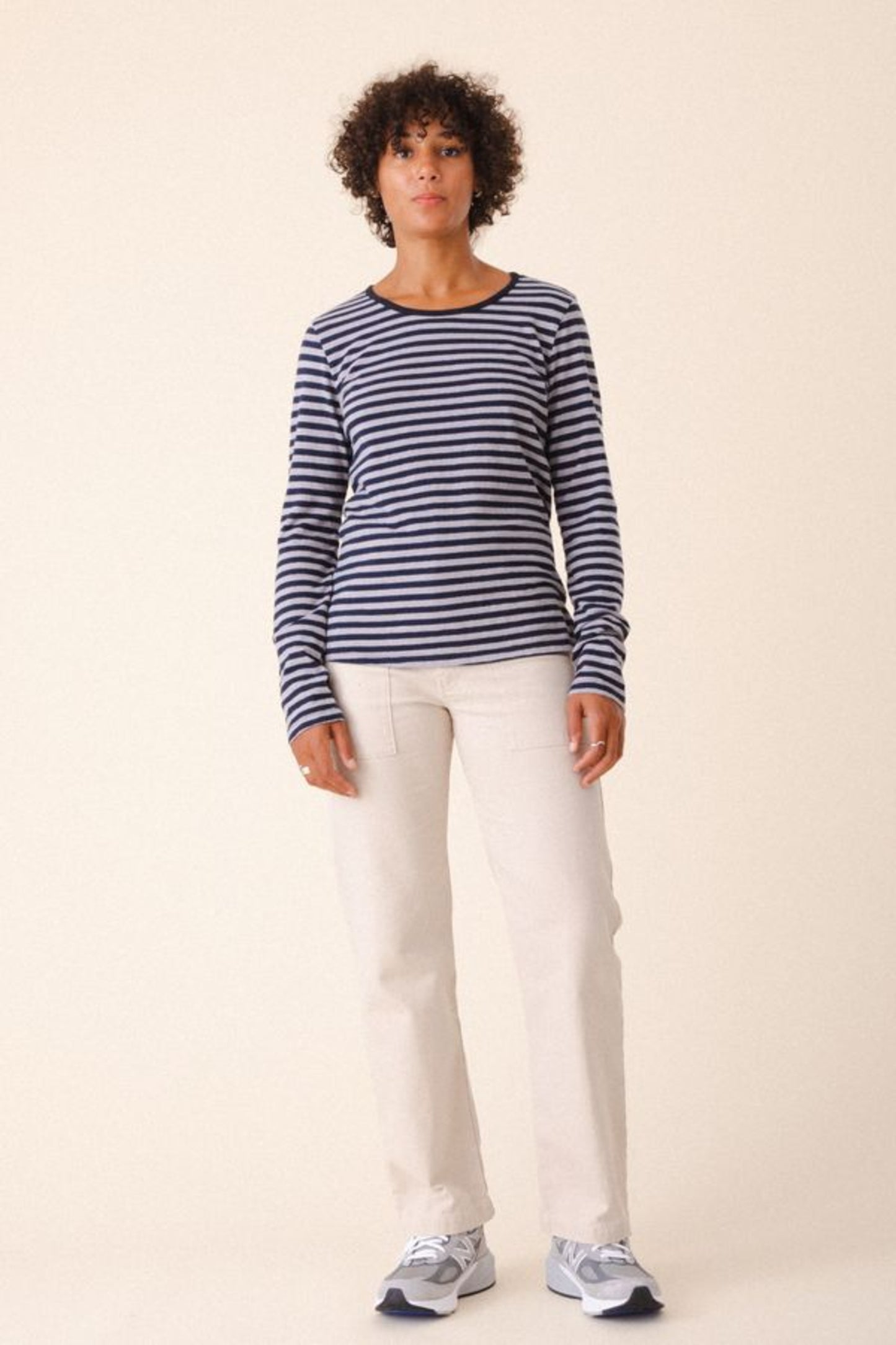 Image of model wearing Prairie Underground Utility Pant in Natural White Organic Cotton Canvas. Utility Pant is a work wear inspired style with a high rise and flattering fit. Designed and produced in Seattle, Washington, USA.
