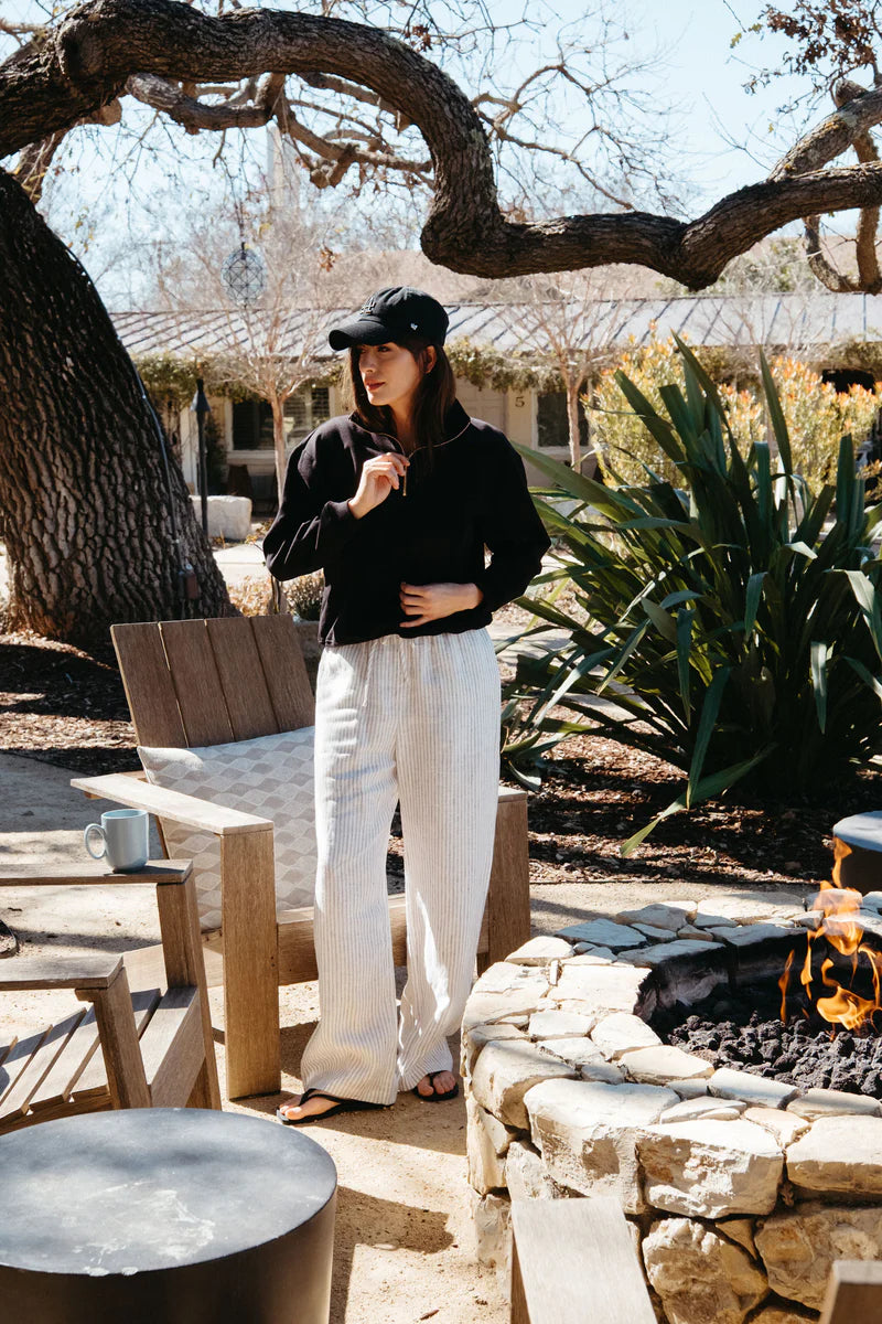 Image of model wearing Whimsy + Row Diana Half Zip Pullover in Black. Made in USA from organic cotton fleece.