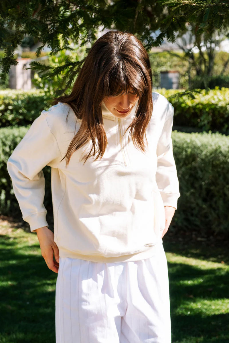 Image of model wearing Whimsy + Row Diana Half Zip Pullover in Cream White. Made in USA from organic cotton fleece.