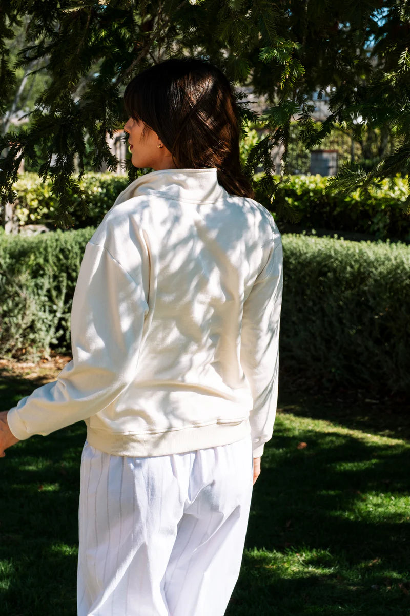 Image of model wearing Whimsy + Row Diana Half Zip Pullover in Cream White. Made in USA from organic cotton fleece.