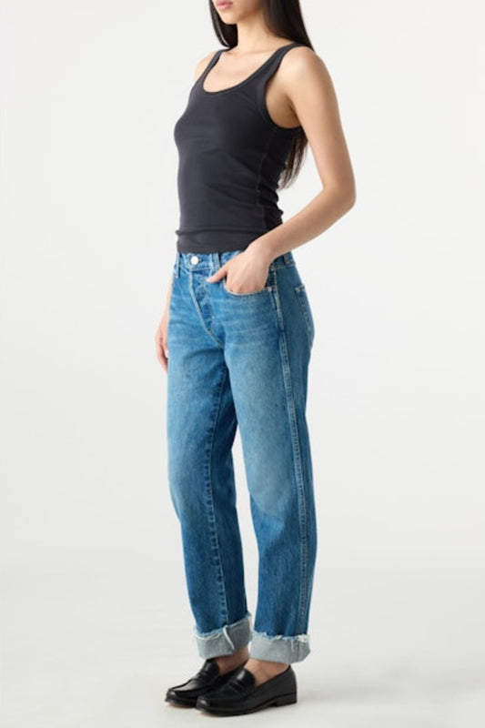 Image of model wearing AMO DENIM Camryn Jean in Magnetic. Cameron is a mid-rise 100% Cotton mid-wash denim with a tapered, straight leg opening. Designed to wear with cuffed hem.