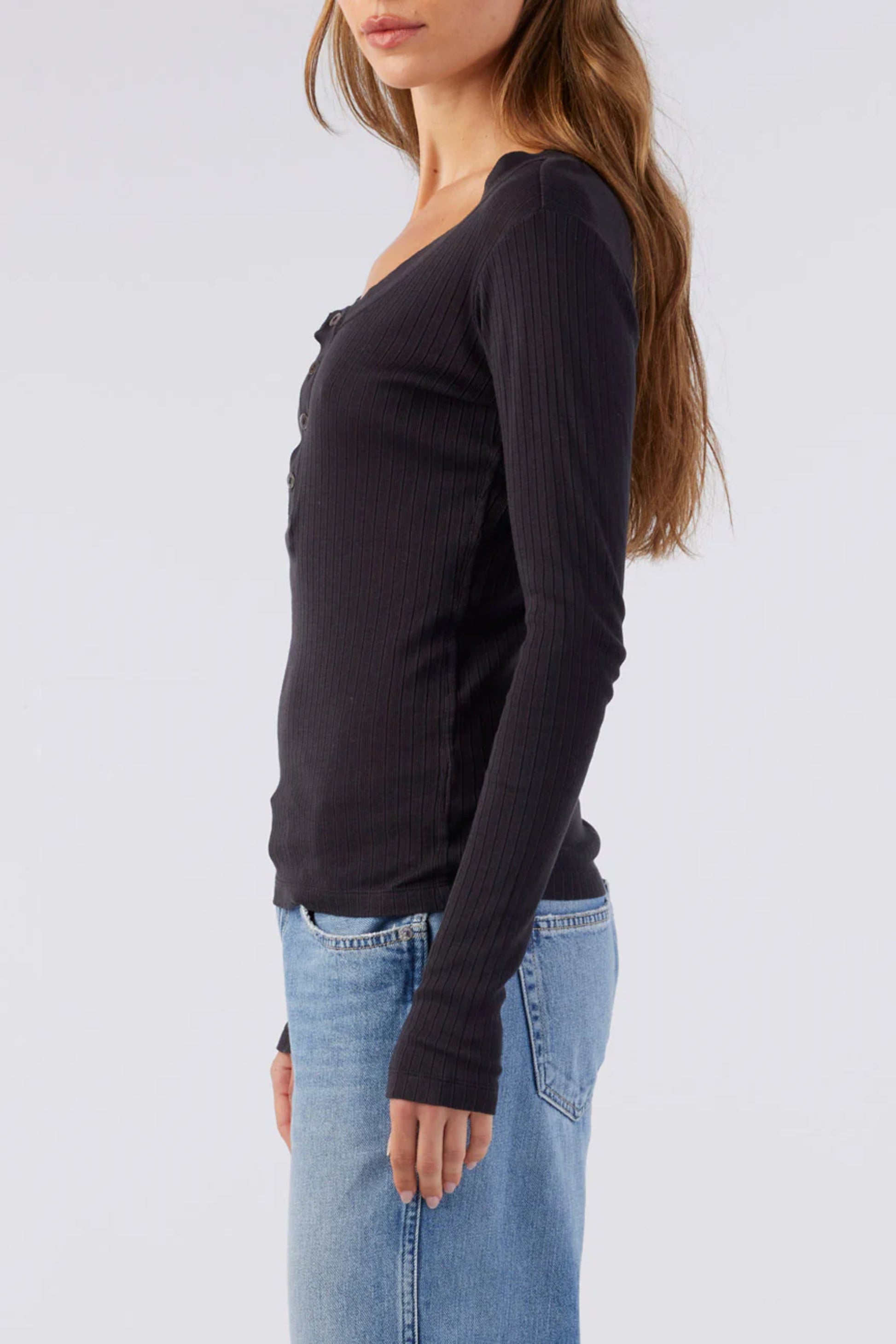 Image of a model wearing AMO Denim Sweets Henley in Vintage Black. Sweets Henley is a Premium Scoop Neck Cotton Henley with tonal button details and subtle ribbing. Made in Portugal. 