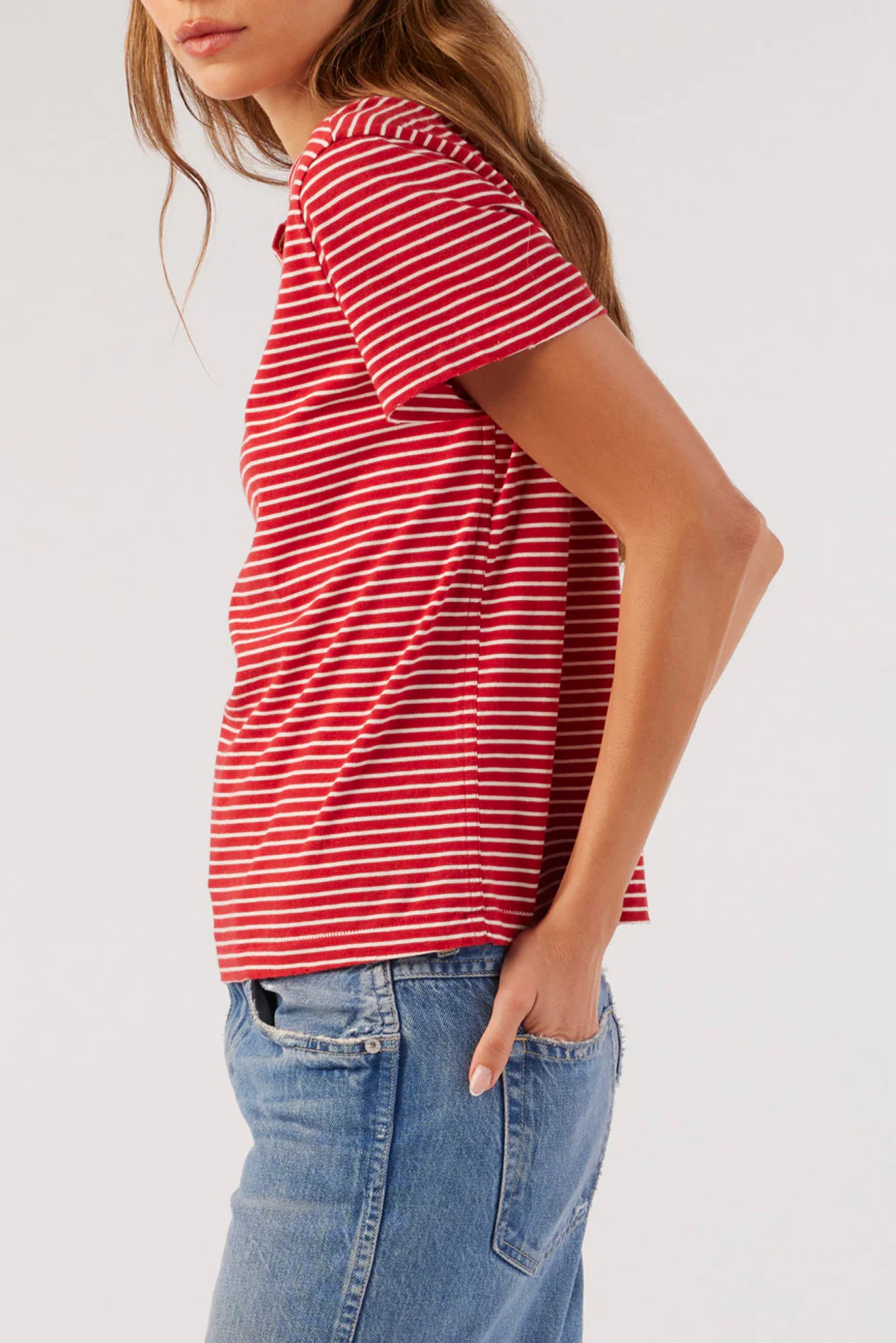 Image on model wearing AMO Cotton Striped Love T-Shirt in Cherry Red with Natural White striping. Made in USA premium denim + basics line; female founded + operated. 