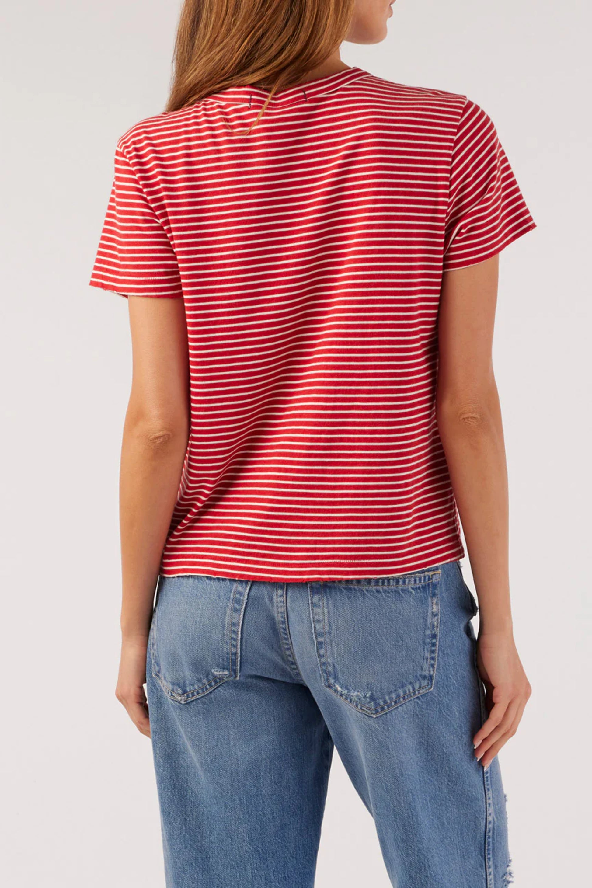 Image on model wearing AMO Cotton Striped Love T-Shirt in Cherry Red with Natural White striping. Made in USA premium denim + basics line; female founded + operated. 