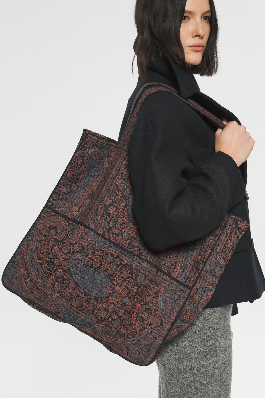 Image of model holding Antik Batik Hand Quilted Cotton Carry-On Tote Bag with Black Paisley Block Print Pattern - Ethically Made French Fashion - Artisan Made Sustainable High Fashion