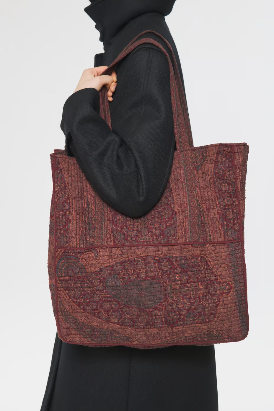 Image of model holding Antik Batik Hand Quilted Cotton Carry-On Tote Bag with Red Paisley Block Print Pattern - Ethically Made French Fashion - Artisan Made Sustainable High Fashion