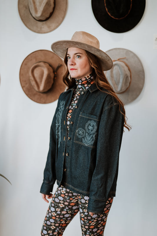 Image of model in Antik Batik Eglantine Indigo Dyed Denim Chore Jacket with Hand Stitched Tonal Floral Embroidery _ Ethical French Bohemian Fashion _ Artisan Made Sustainable High Fashion