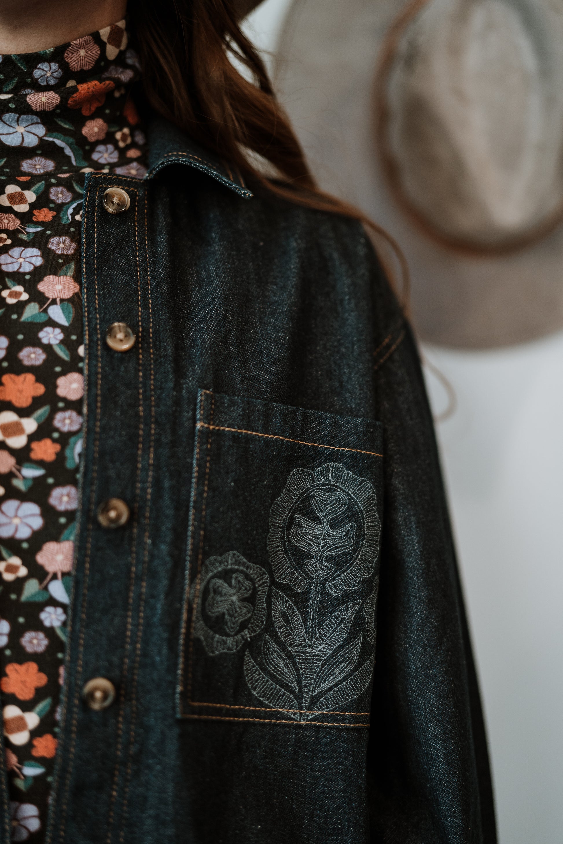 Close up of Hand Embroidery details on Antik Batik Eglantine Indigo Dyed Denim Chore Jacket with Hand Stitched Tonal Floral Embroidery _ Ethical French Bohemian Fashion _ Artisan Made Sustainable High Fashion