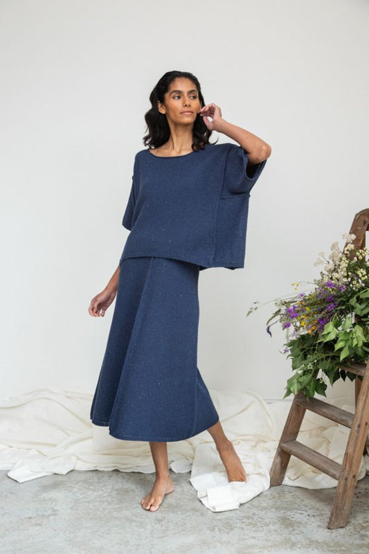 Image of model wearing Beaumont Organic Alessia Leigh Wide Knit Top in Denim Blue. Alessia is a boxy boatneck sweater top with a dropped shoulder and elbow length sleeve. Ethically made in Portugal from recycled Cotton yarns.