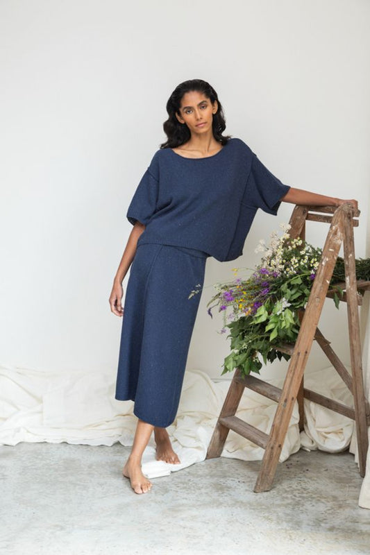 Image of model wearing Beaumont Organic Alessia Leigh Wide Knit Top in Denim Blue. Alessia is a boxy boatneck sweater top with a dropped shoulder and elbow length sleeve. Ethically made in Portugal from recycled Cotton yarns.