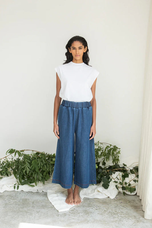 Image of model wearing Beaumont Organic Evora Leigh Wide Leg Trouser. Evora Leigh is a draped, pull-on, wide leg trouser with slightly cropped length. Ethically made in Portugal from organic cotton denim.