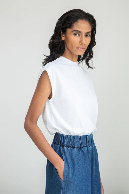 Image of model wearing Beaumont Organic Aukui T-Shirt in True White. Aukui is a cap sleeve tee with high crew neck and medium body length. Ethically made in Portugal from organic cotton.