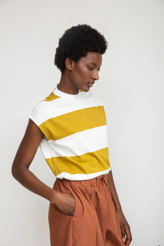 Image of model wearing Beaumont Organic Aukui T-Shirt in True White. Aukui is a cap sleeve tee with high crew neck and  medium body length. Ethically made in Portugal from organic cotton.