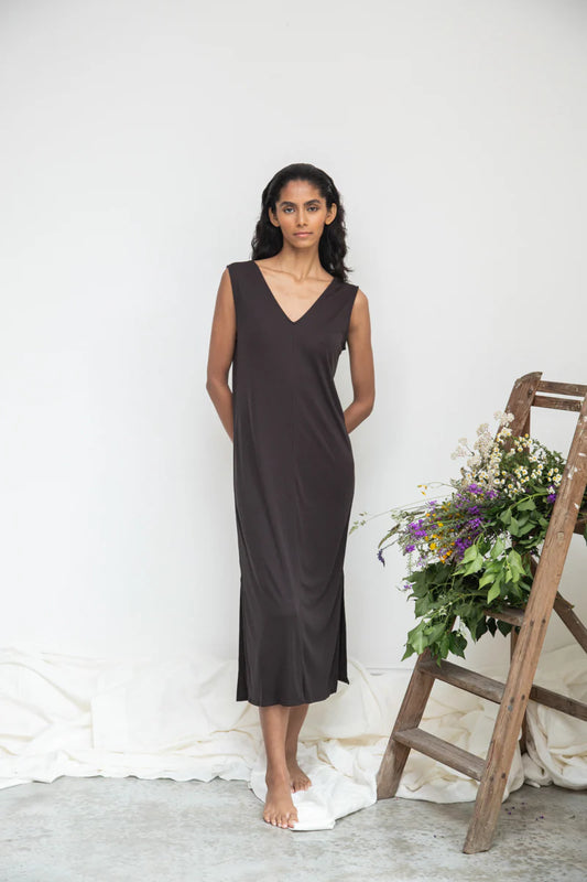Image of model wearing Beaumont Organic Catalina Lou Column Dress in Charcoal Lyocell. Catalina Dress has a v-neck front and v-back with a midi length and symmetrical side slits; optional waist sash. Ethically made in Portugal.
