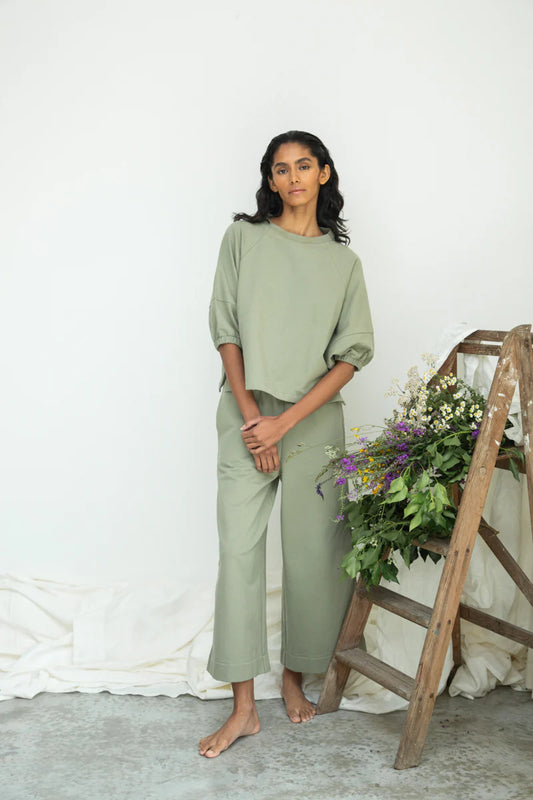 Image of model wearing Beaumont Organic Helios Sweatshirt in Pistachio Green Felpe Cotton. Helios is a medium length sweatshirt top with fashionable princess sleeves that hit at the elbow. Ethically made in Portugal from organic Cotton.