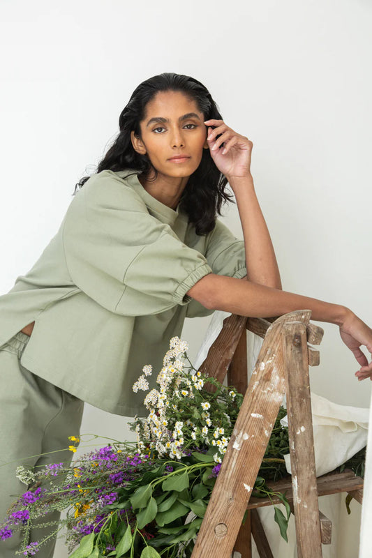 Image of model wearing Beaumont Organic Helios Sweatshirt in Pistachio Green Felpe Cotton. Helios is a medium length sweatshirt top with fashionable princess sleeves that hit at the elbow. Ethically made in Portugal from organic Cotton.