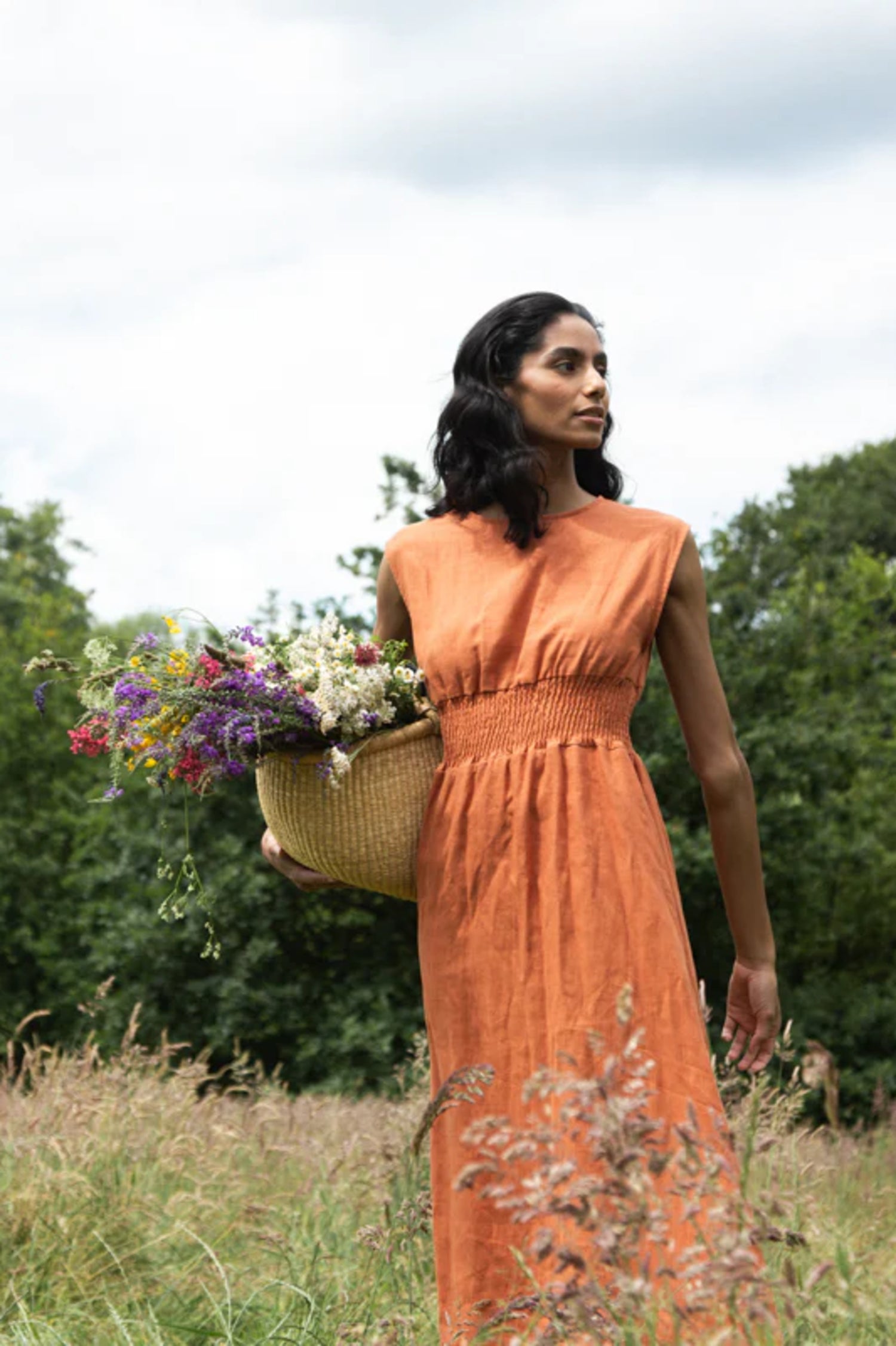 Image of model wearing Beaumont Organic Ottillie May Gathered Waist Midi Sundress in Terracotta Linen. Ethically made in Portugal. 