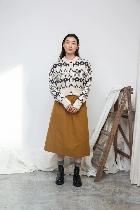 Image of model wearing BEAUMONT ORGANIC Sugi Sue Organic Cotton Knit Cardigan with Geometric Charcoal Fair Isle on Ivory yarn.