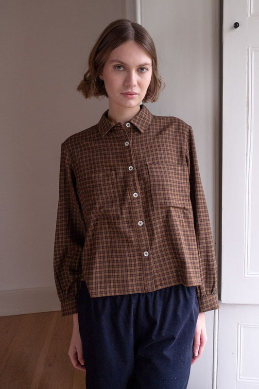 Image of model wearing BIBICO Fair Trade Clothing Ada Button Down Blouse in Rust Check Flannel. 