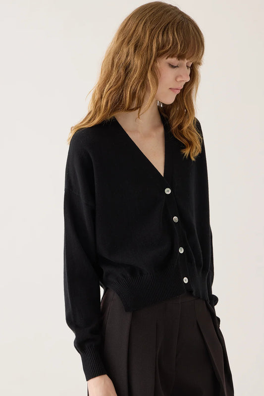 Image of DEMYLEE Lola Cardigan in True Black. Lola Cardigan has a classic, loose fit with an open vneck line and iridescent pearl buttons. Made from cotton-cashmere.