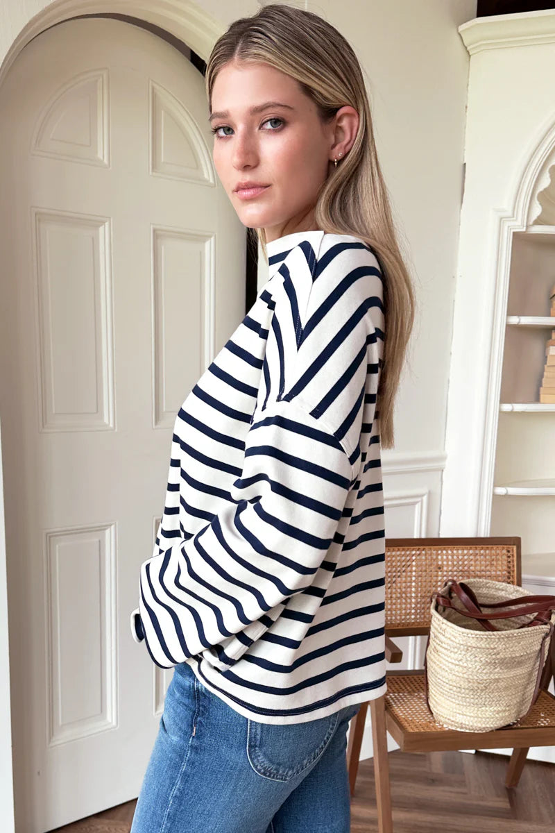 Image of model wearing Emerson Fry Bateau Top in Navy Stripe. Bateau top is a cotton rib boatneck top with dropped shoulder and boxy body in a classic white and navy blue stripe. 