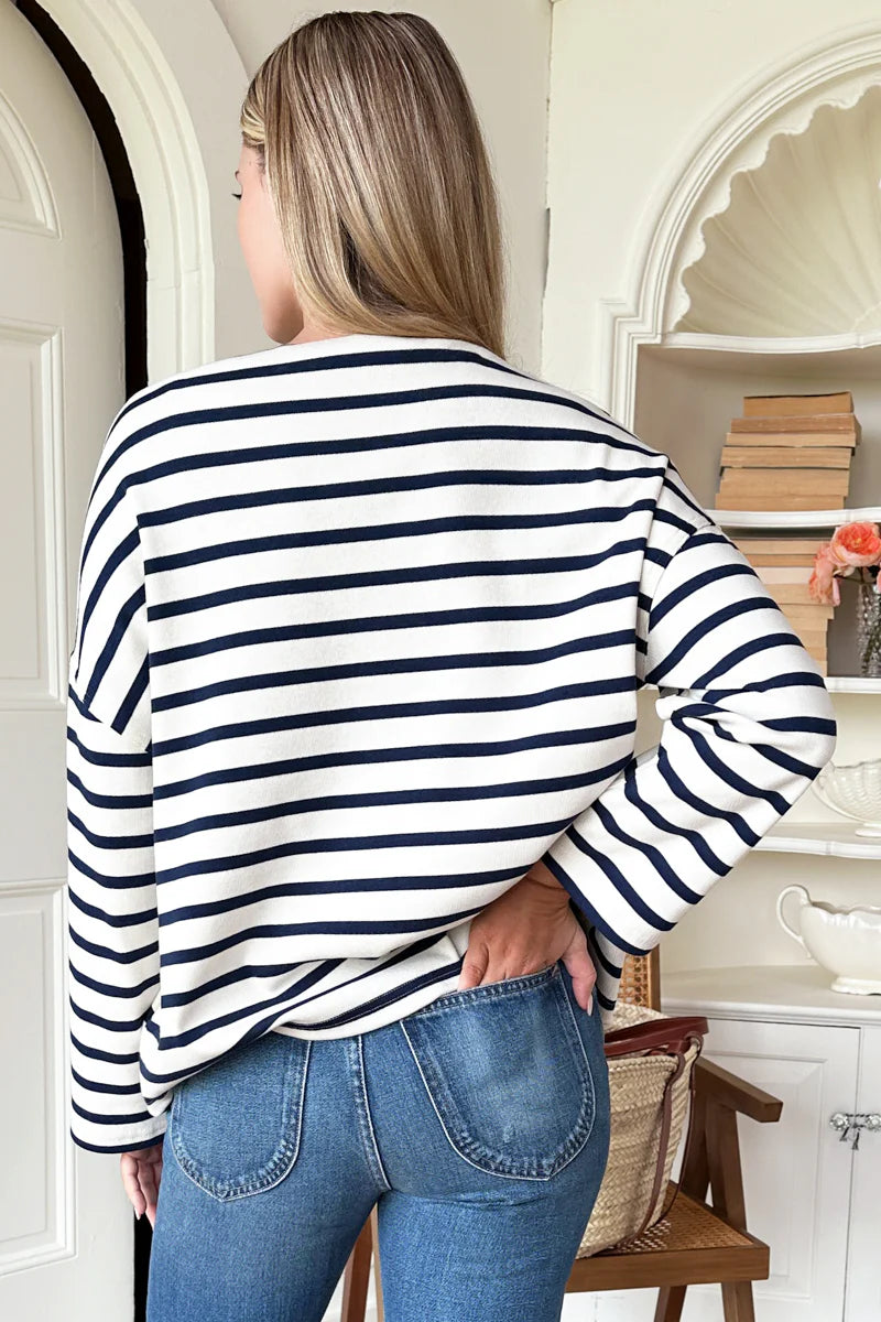 Image of model wearing Emerson Fry Bateau Top in Navy Stripe. Bateau top is a cotton rib boatneck top with dropped shoulder and boxy body in a classic white and navy blue stripe. 